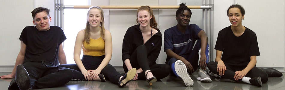 Dance students sat on the floor.